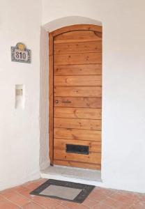 a wooden door in a room with a mat in front at Calarossa Bay in Isola Rossa