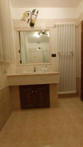 a bathroom with a sink and a mirror and a radiator at B&B Villa Cinzia Ledro in Ledro