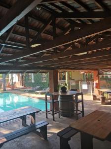 un patio con mesa y bancos junto a una piscina en Ocean Park Guest House, en Umkomaas