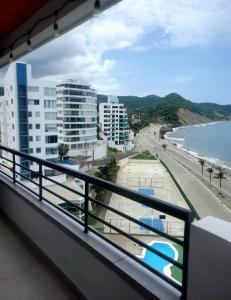 een balkon met uitzicht op het strand en de gebouwen bij Pelican View & Sunsets! in Bahía de Caráquez