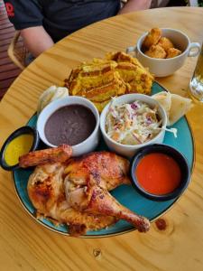 une assiette de nourriture avec du poulet et d'autres aliments sur une table dans l'établissement Vulkan Arenal Amazing View Lodge 4 WD, à El Castillo de la Fortuna