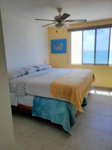 een slaapkamer met een bed en een plafondventilator bij Pelican View & Sunsets! in Bahía de Caráquez
