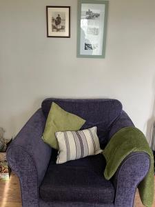 a blue couch with green and white pillows on it at Turning Tides Holiday Cottage in Great Yarmouth