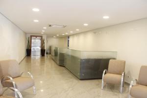 - un hall avec deux chaises et un bureau en verre dans l'établissement Floresta Hotel, à São Paulo
