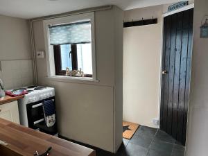 a kitchen with a stove and a window at Turning Tides Holiday Cottage in Great Yarmouth +47 photos