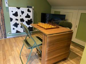 a chess board on a wooden table with a chair at CasaDeKaMa in Evergem