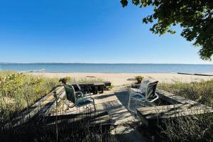een tafel en stoelen op het strand bij Beach Retreat in Harbor Springs