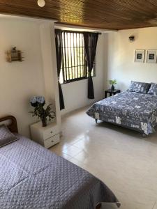 a bedroom with two beds and two windows at Habitaciones independientes cerca al aeropuerto 1 in Cartagena de Indias