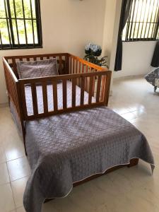 1 cama con marco de madera en una habitación en Habitaciones independientes cerca al aeropuerto 1 en Cartagena de Indias