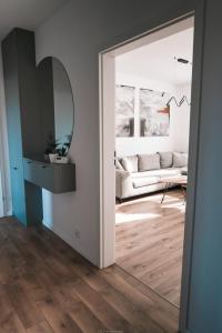 a living room with a couch and a mirror at Apartament Komfort in Słupsk