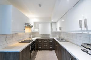 cocina grande con electrodomésticos blancos y armarios marrones en University of Bath City Accommodation, en Bath