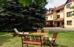 una mesa de picnic y sillas en un patio junto a una casa en Garni-Hotel Kranich en Potsdam