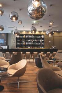 a tasting room with a bar with chairs and lights at Motel One Manchester-Piccadilly in Manchester