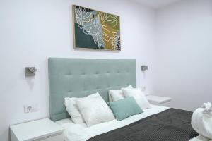 een slaapkamer met een bed met een groen hoofdeinde bij Amazing spacious 1 bedroom flat with Ocean view in Playa Fañabe