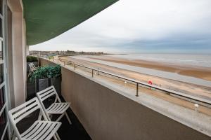 2 sillas en un balcón con vistas a la playa en Midland Hotel, en Morecambe