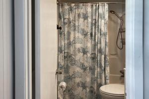 a bathroom with a toilet and a shower curtain at Sunnyside Studio in Panama City Beach