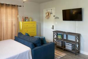 a living room with a blue couch and a tv at Sunnyside Studio in Panama City Beach