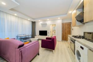 sala de estar con 2 sillas de color púrpura y cocina en Char, en Antalya