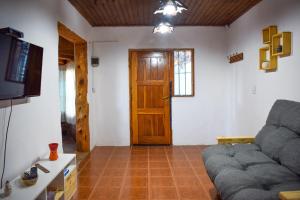 sala de estar con sofá y puerta de madera en El ciruelo Bariloche en San Carlos de Bariloche