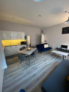 a living room with a table and a blue couch at Modern and spacious city centre apartment in Dublin