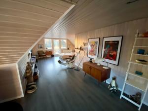 a living room with a wooden floor and a staircase at feriehus med havudsigt in Spodsbjerg