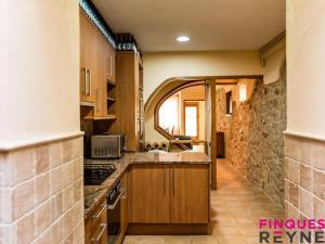 a kitchen with wooden cabinets and a counter top at Casa Monestir in Sant Feliu de Guíxols