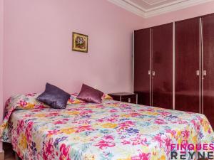 a bedroom with a large bed with a colorful blanket at Casa Monestir in Sant Feliu de Guíxols