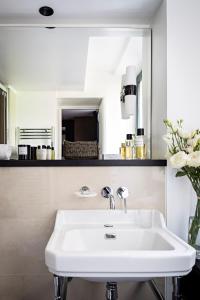 a white sink in a bathroom with a mirror at Holiday Inn Paris Palais de l'Elysée by IHG in Paris +79 photos