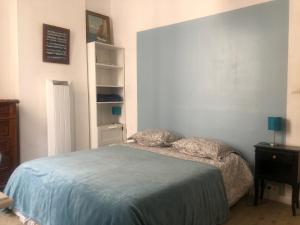 - une chambre avec un lit et une couverture bleue dans l'établissement Appt 2 chambres au centre ville 3è, à Marseille