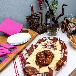un tavolo con un piatto di cibo e bottiglie di vino di Sobe Šokac a Trenkovo