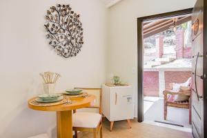 a dining room with a table and a refrigerator at Pousada Alto de Monte Verde in Monte Verde