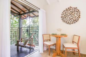 a dining room with a table and chairs and a window at Pousada Alto de Monte Verde in Monte Verde