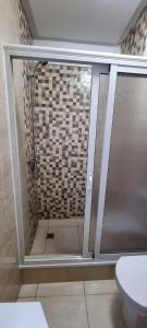 a shower with a glass door in a bathroom at مراكش.شارع الحسن التاني in Aït Saïd