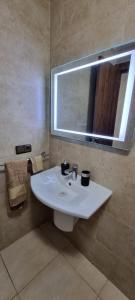 a bathroom with a white sink and a mirror at مراكش.شارع الحسن التاني in Aït Saïd