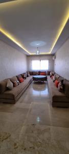 uma grande sala de estar com sofás e uma mesa em مراكش.شارع الحسن التاني em Aït Saïd