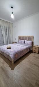 um quarto com uma cama grande num quarto em مراكش.شارع الحسن التاني em Aït Saïd
