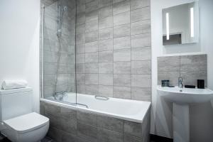 a bathroom with a tub and a toilet and a sink at Apartments in Peterborough City Centre - Bayard Plaza in Peterborough +12 photos