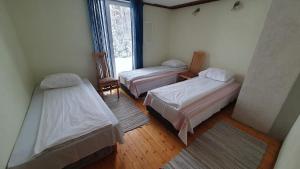 a room with two beds and a window at Kooli talu puhkemaja in Valingu