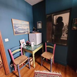 a room with a table with two chairs and a desk with a microwave at L'Atelier Bed and Breakfast in Andrimont