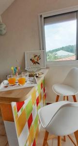 a kitchen with a table and chairs and a window at Vue sur mer à la Villa Parme in Le Robert