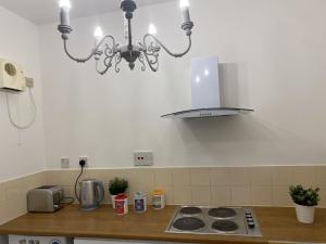 a kitchen with a stove and a chandelier at Inviting 1-Bed Apartment in Merchant City in Glasgow