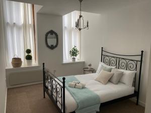 - une chambre avec un lit noir et blanc et des oreillers blancs dans l'établissement Inviting 1-Bed Apartment in Merchant City, à Glasgow