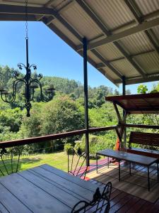 a porch with a picnic table and a chandelier at Forest View Cottage in Pietermaritzburg