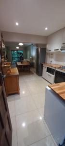 a large kitchen with a large white tile floor at Forest View Cottage in Pietermaritzburg
