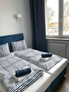 two beds with towels on top of them in a bedroom at Aparthotel Dworzec in Elblag