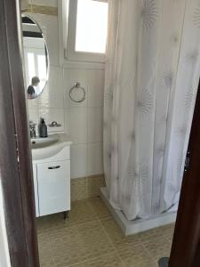 a bathroom with a sink and a shower curtain at Christos in Rafina