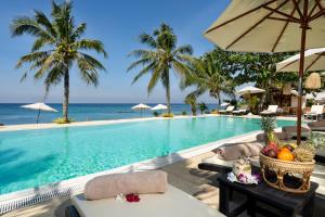 ランタ島にあるLanta Palace Beach Resort & Spa - Adult Onlyのテーブルとパラソル付きのプールを提供しています。