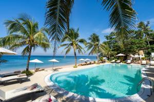 einen Pool am Strand mit Palmen und dem Meer in der Unterkunft Lanta Palace Beach Resort & Spa - Adult Only in Ko Lanta
