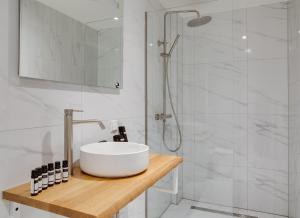 uma casa de banho branca com um lavatório e um chuveiro em The Sixteen em Amesterdão