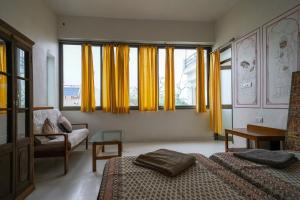 a bedroom with two beds and yellow curtains at Tourist Pension in Nawalgarh